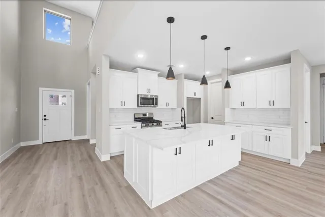a large white kitchen with wooden floor