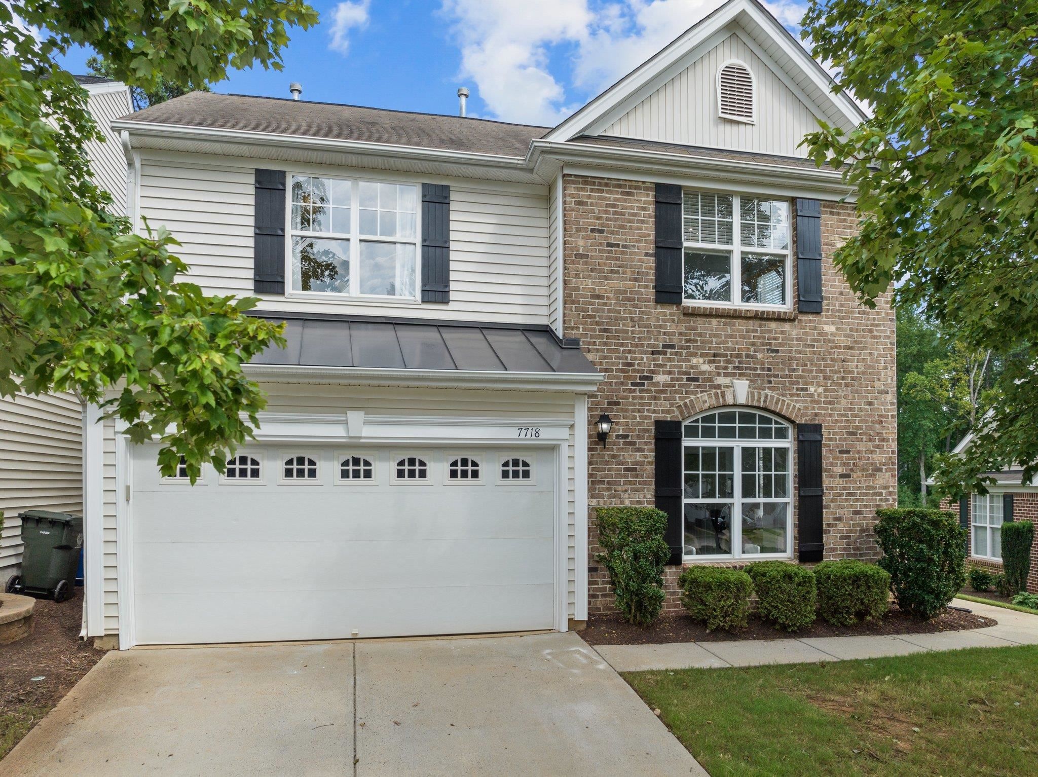 7718 Cape Charles Drive Raleigh, NC 27617 - Photo 1 of 43 a view of a white house with potted plants and a large tree