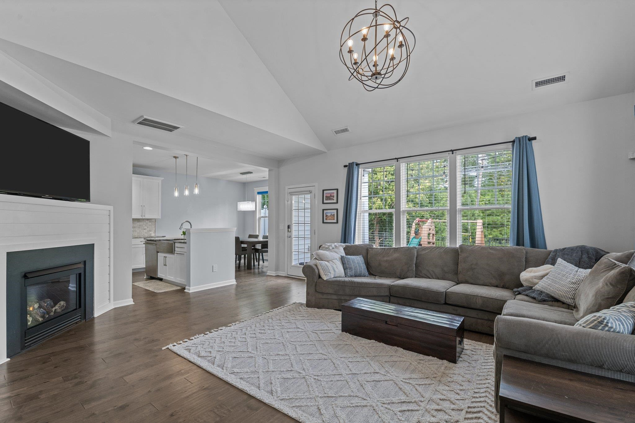 7718 Cape Charles Drive Raleigh, NC 27617 - Photo 11 of 43 a living room with furniture a large window and a fireplace