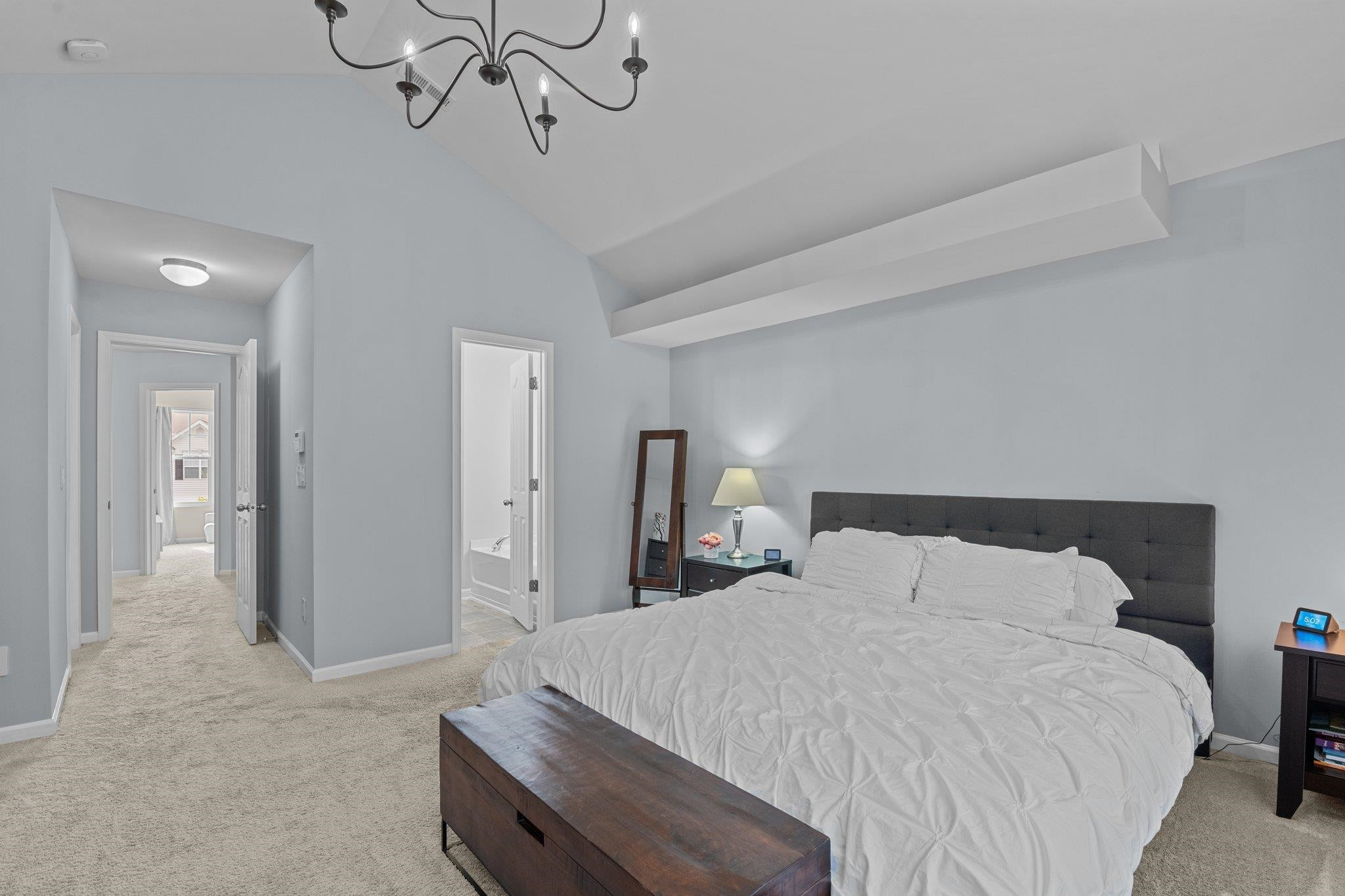 7718 Cape Charles Drive Raleigh, NC 27617 - Photo 21 of 43 a bedroom with a bed and a chandelier