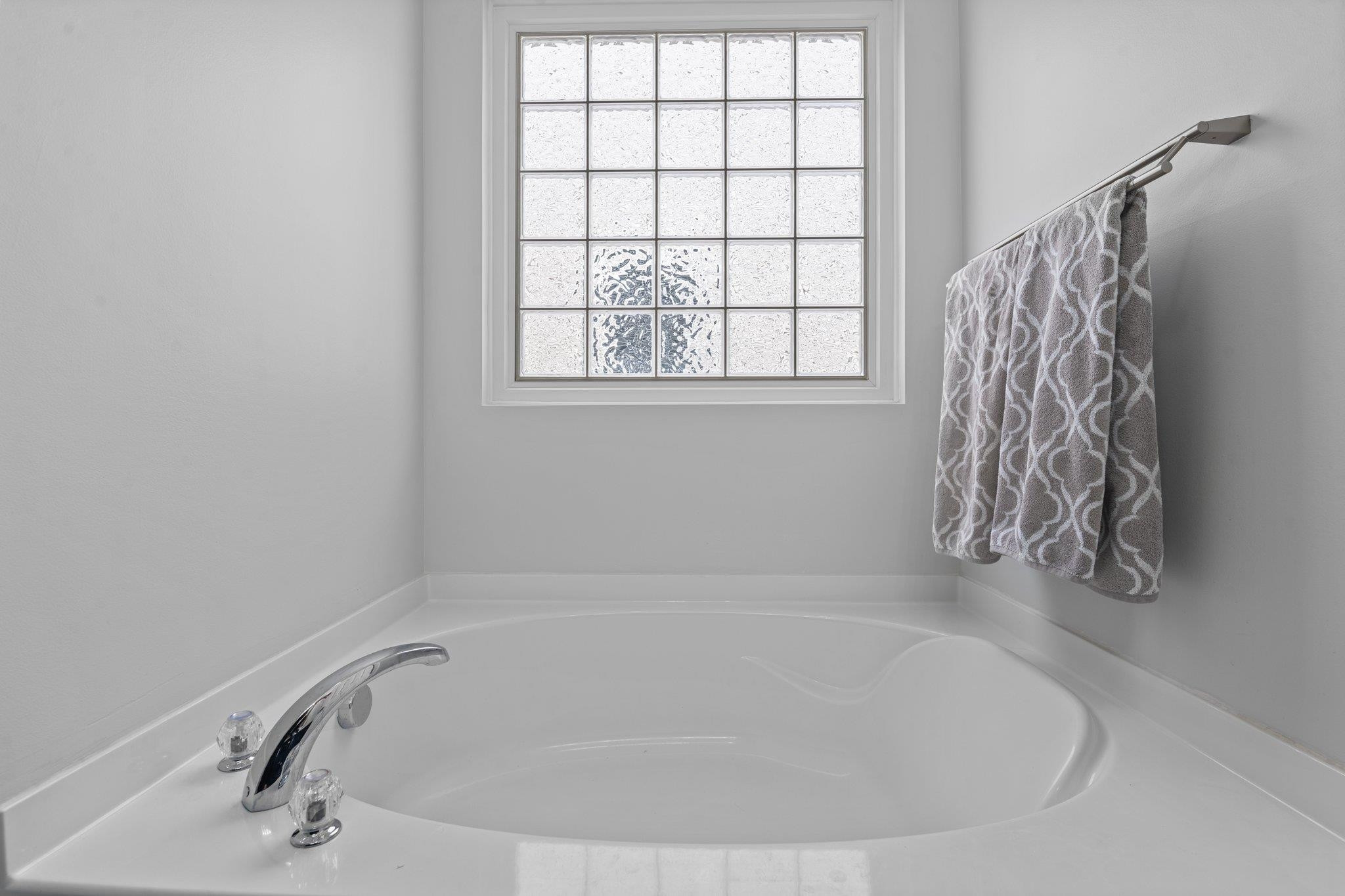 7718 Cape Charles Drive Raleigh, NC 27617 - Photo 24 of 43 a white bath tub sitting in a bathroom next to a window