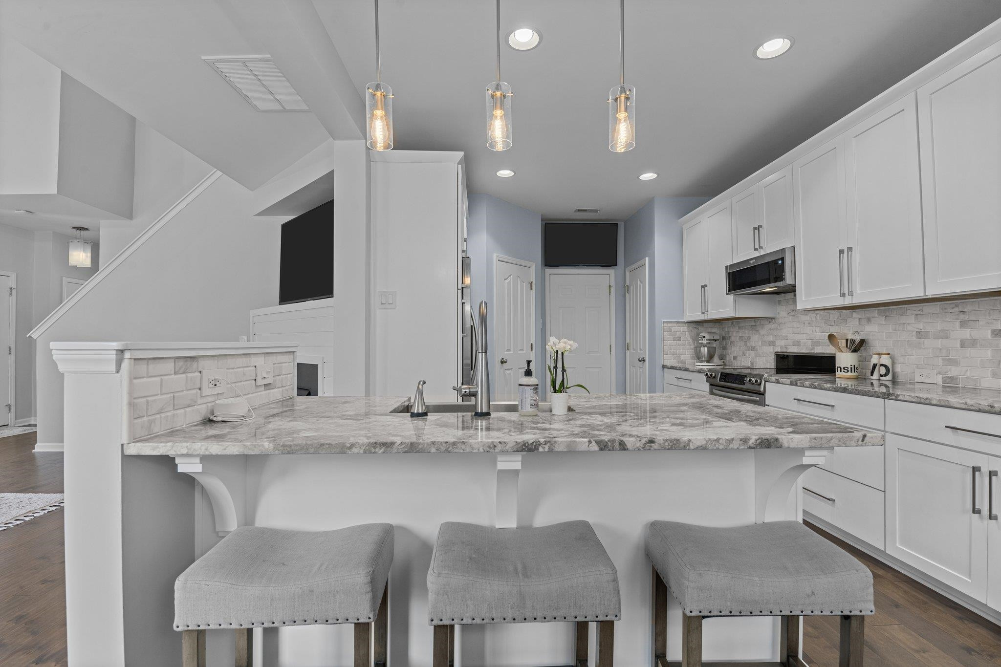 7718 Cape Charles Drive Raleigh, NC 27617 - Photo 4 of 43 a kitchen with stainless steel appliances granite countertop a sink a stove a microwave a dining table and chairs