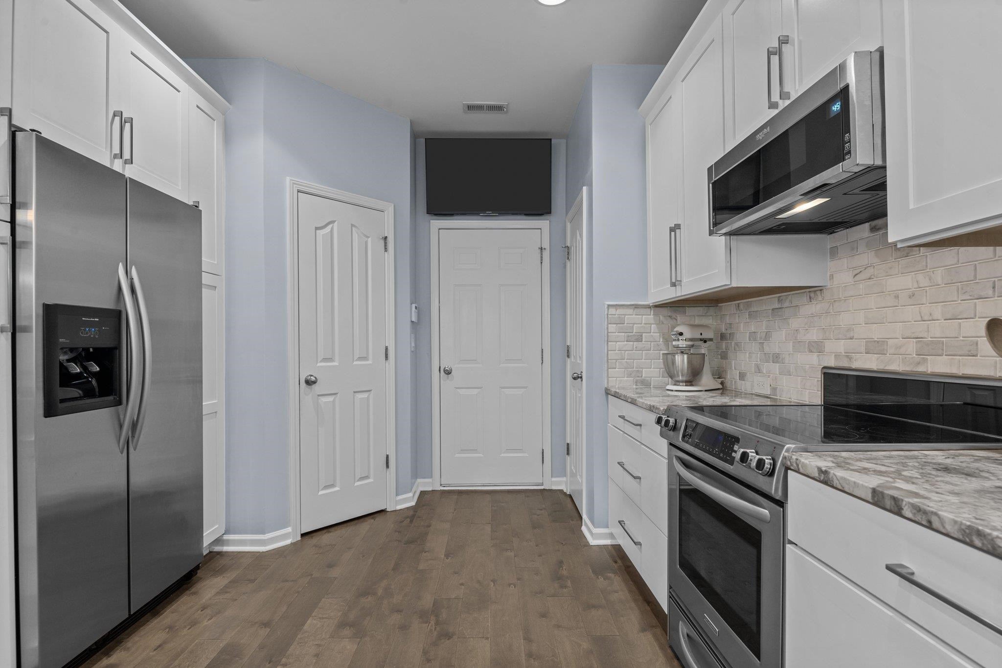 7718 Cape Charles Drive Raleigh, NC 27617 - Photo 6 of 43 a kitchen with stainless steel appliances granite countertop a stove a refrigerator and a microwave