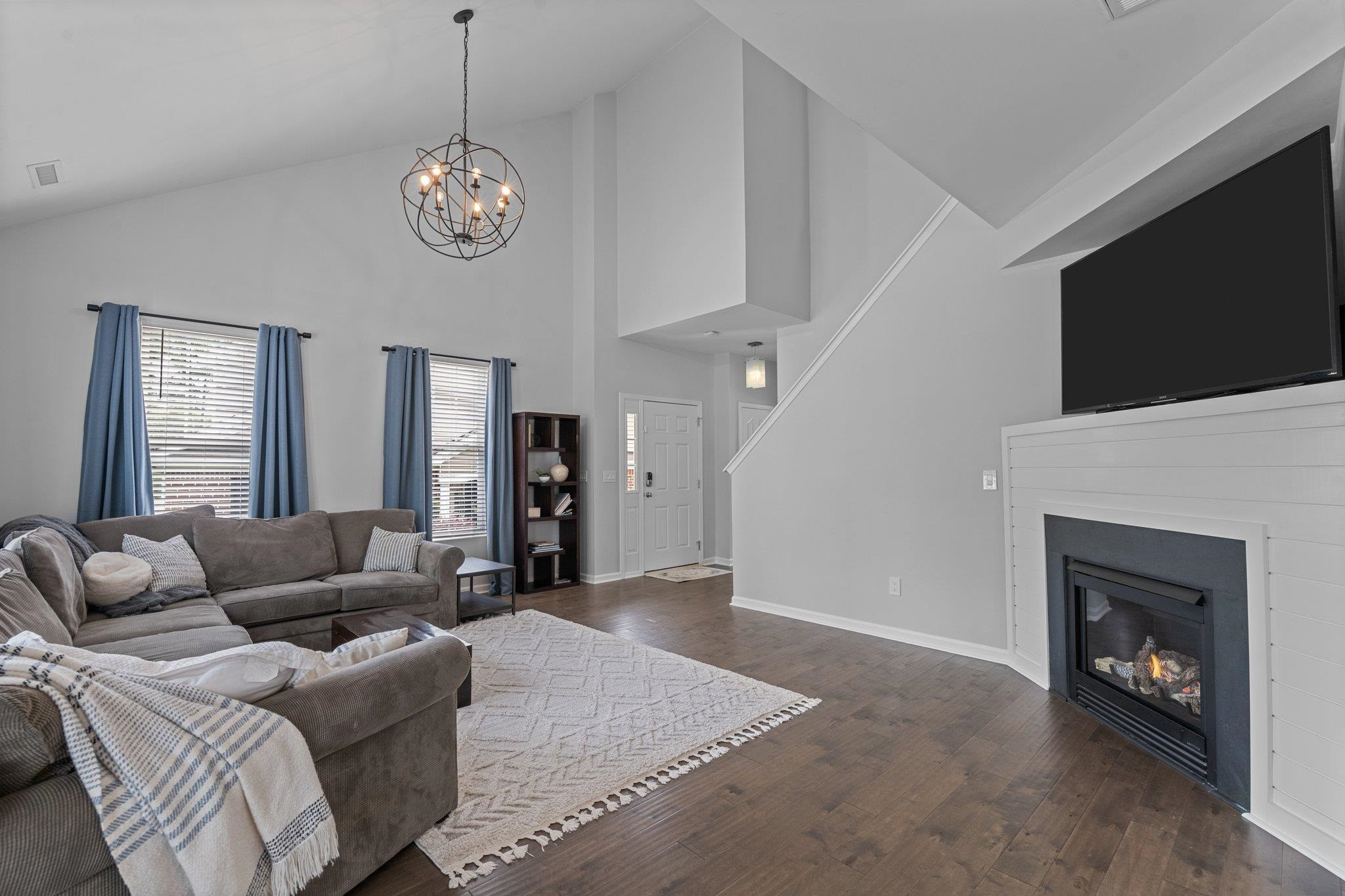 7718 Cape Charles Drive Raleigh, NC 27617 - Photo 9 of 43 a living room with furniture a fireplace and a flat screen tv