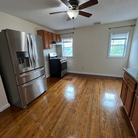 a kitchen with granite countertop stainless steel appliances a refrigerator microwave and stove