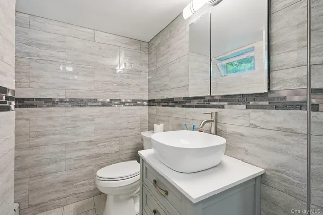 a bathroom with a sink a toilet and mirror