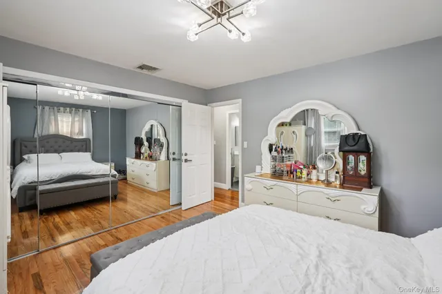 a bedroom with a bed and a mirror on dresser
