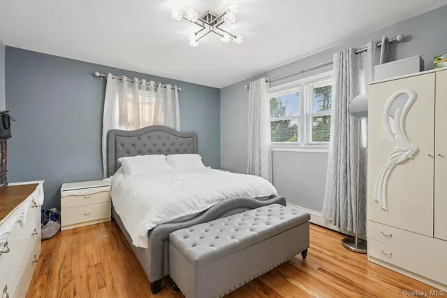 a bedroom with a bed wooden floor and window