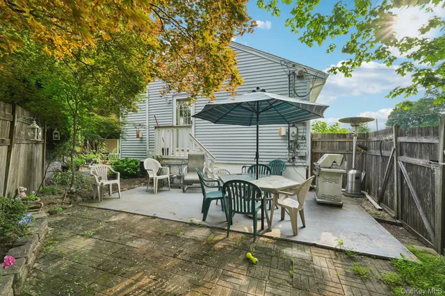 a view of a patio with table and chairs under an umbrella