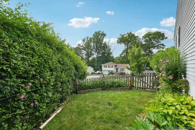 a view of a house with a small yard and a garden