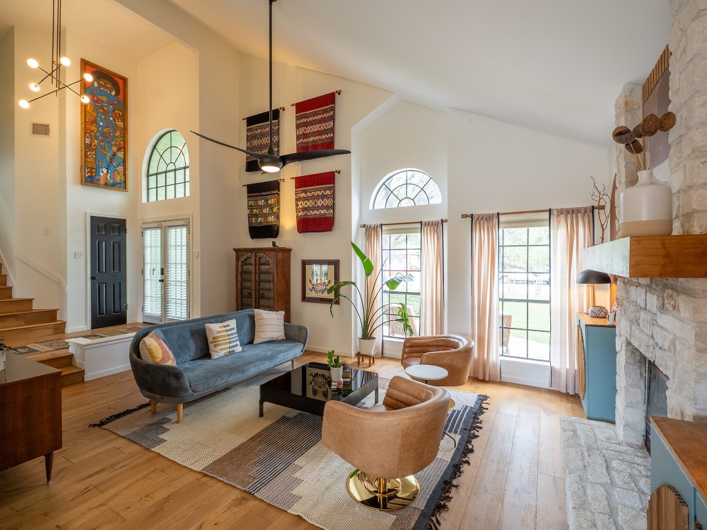 a living room with fireplace furniture and a large window