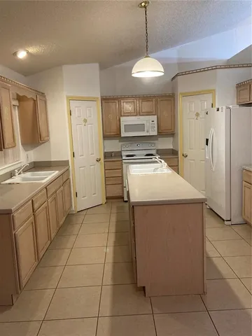 a kitchen with a sink window and refrigerator