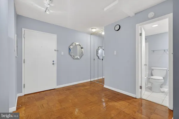a view of a room with wooden floor and mirror