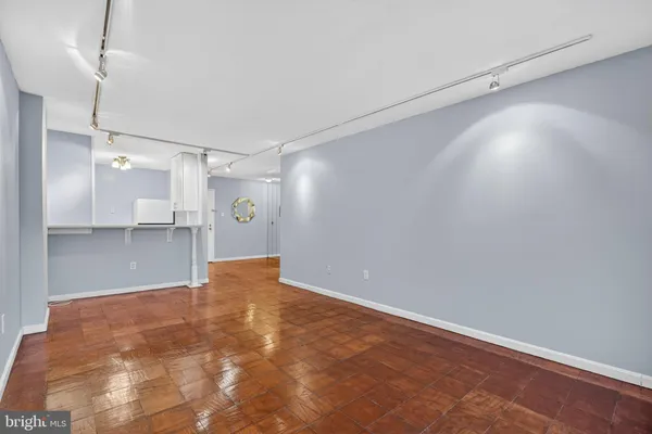 a view of a big room with wooden floor and a ceiling fan