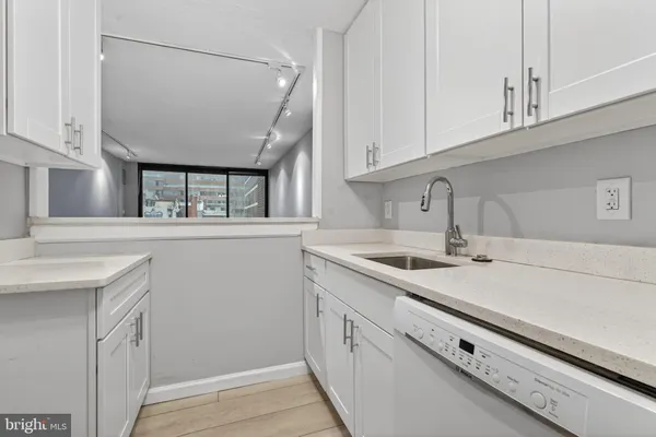 a kitchen with stainless steel appliances granite countertop a sink and dishwasher with white cabinets
