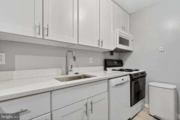 a kitchen with white cabinets and white appliances
