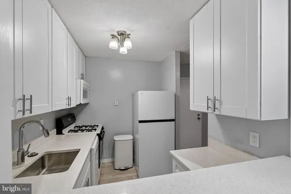 a kitchen with stainless steel appliances granite countertop a sink a refrigerator and a stove top oven