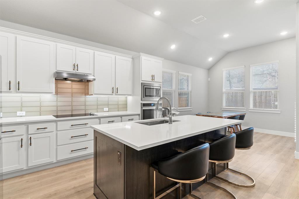 5823 Heatherwood Loop Sachse, TX 75048 - Photo 15 of 40 a kitchen with sink stove and chairs