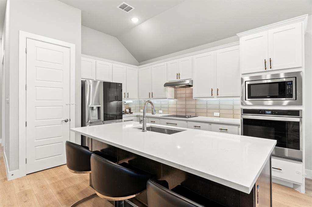 5823 Heatherwood Loop Sachse, TX 75048 - Photo 16 of 40 a kitchen with stainless steel appliances a stove refrigerator sink and cabinets
