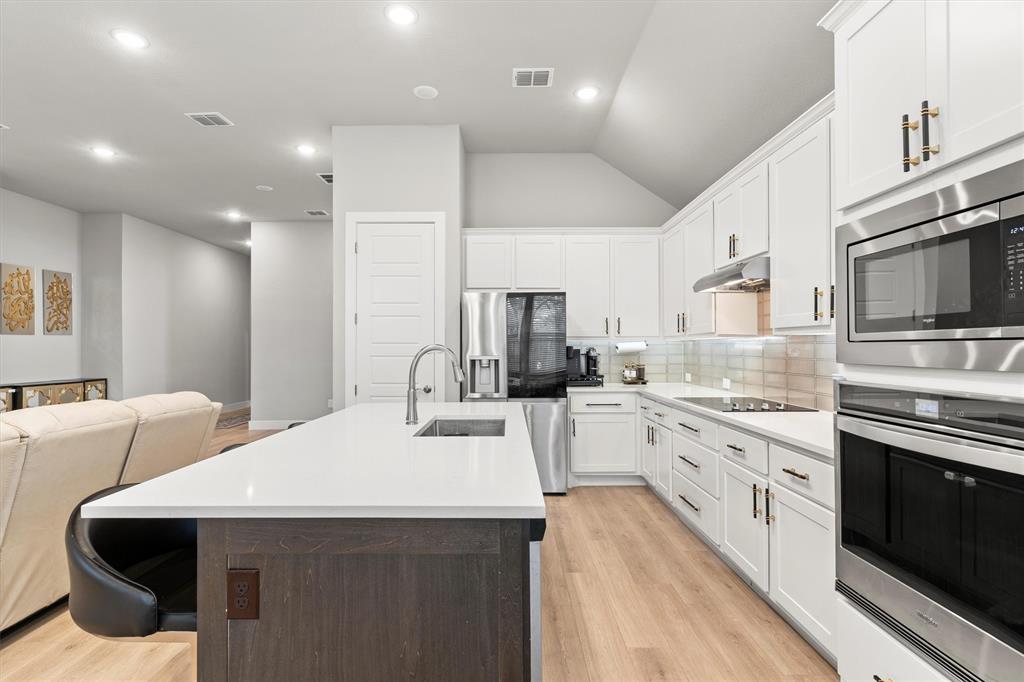 5823 Heatherwood Loop Sachse, TX 75048 - Photo 17 of 40 a kitchen with stainless steel appliances kitchen island granite countertop a sink and cabinets