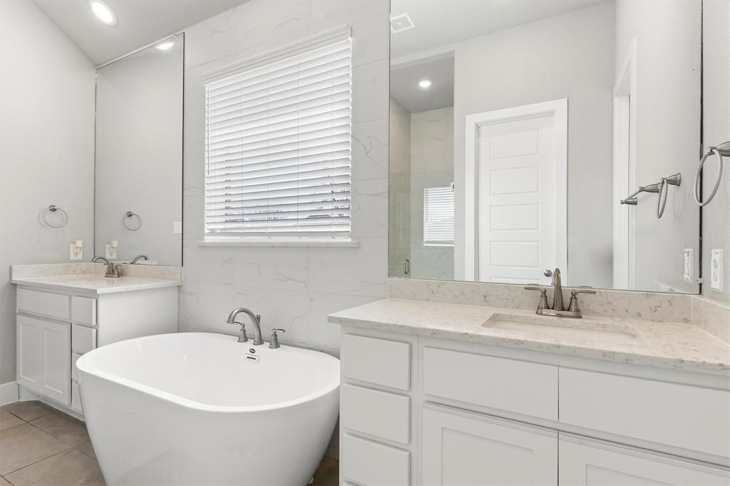 5823 Heatherwood Loop Sachse, TX 75048 - Photo 23 of 40 a bathroom with a white sink a mirror and a bathtub