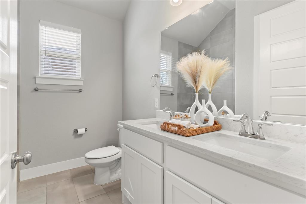 5823 Heatherwood Loop Sachse, TX 75048 - Photo 27 of 40 a bathroom with a toilet sink and mirror