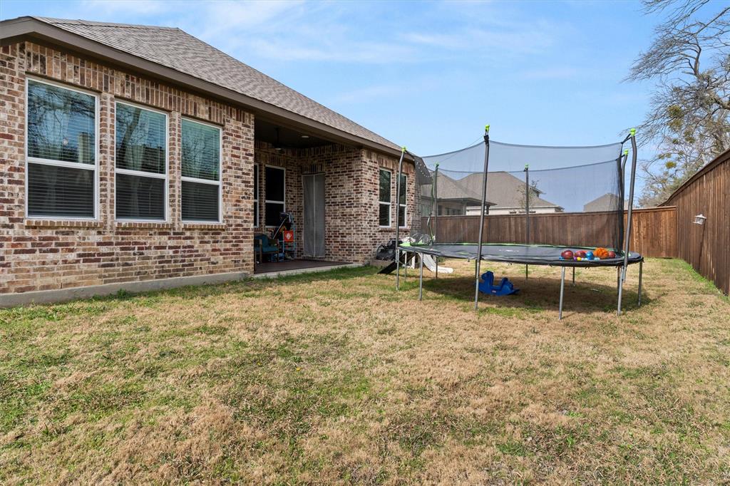 5823 Heatherwood Loop Sachse, TX 75048 - Photo 34 of 40 a backyard of a house with barbeque oven table and chairs