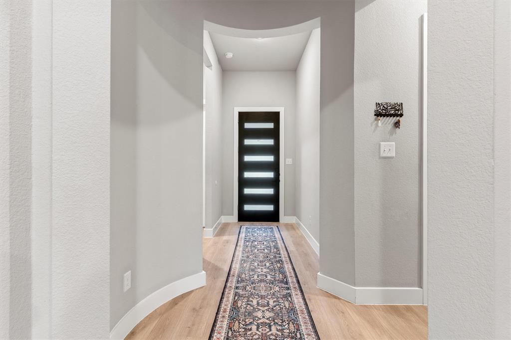 5823 Heatherwood Loop Sachse, TX 75048 - Photo 4 of 40 a view of a hallway with wooden floor and a bathroom