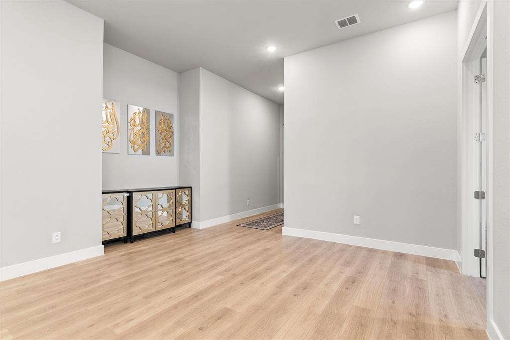 5823 Heatherwood Loop Sachse, TX 75048 - Photo 6 of 40 an empty room with wooden floor and windows