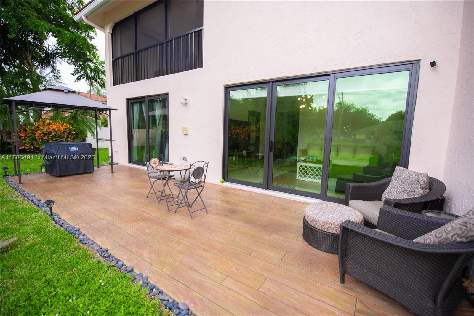 8694 Vía Reale, Unit 3 Boca Raton, FL 33496 - Photo 14 of 15 a view of a patio with a table chairs and a backyard