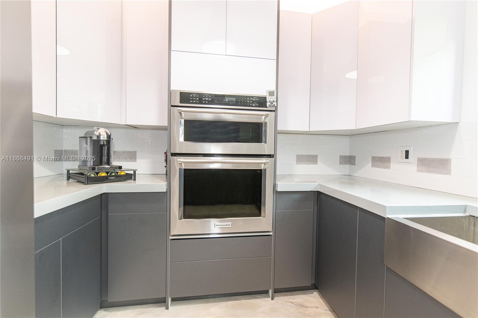 8694 Vía Reale, Unit 3 Boca Raton, FL 33496 - Photo 4 of 15 a kitchen with stainless steel appliances granite countertop a stove a sink and a microwave