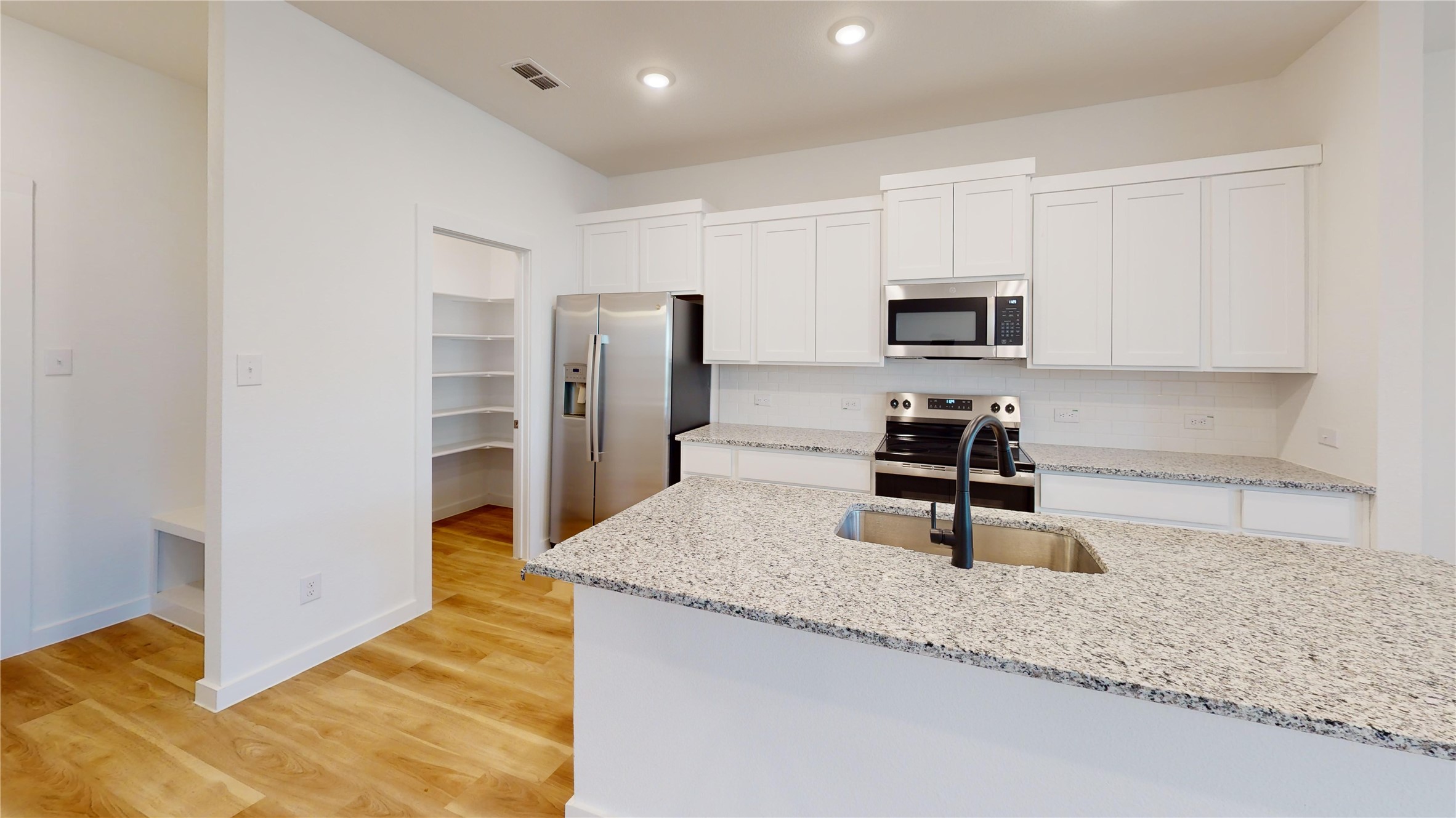 4118 Ruth Alley Grand Prairie, TX 75052 - Photo 19 of 42 a kitchen with stainless steel appliances granite countertop a sink refrigerator and microwave