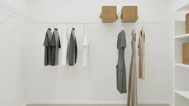 a view of walk in closet with clothes