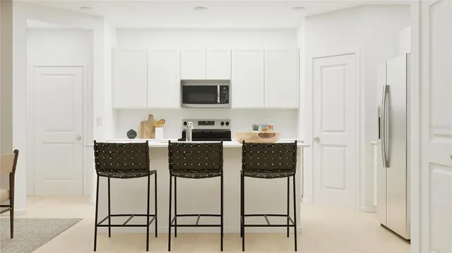 a living room with furniture a flat screen tv and kitchen view