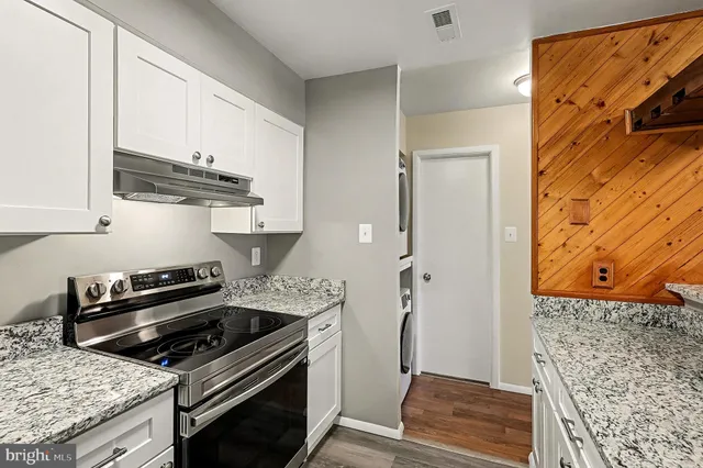 a kitchen with stainless steel appliances granite countertop a stove and a refrigerator