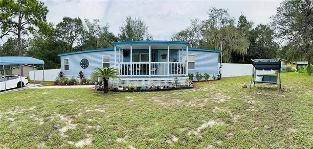 a view of a house with a yard and sitting area