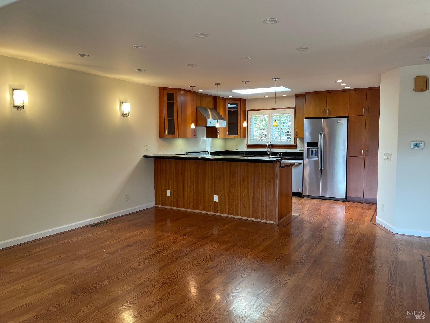48 Marin Avenue Sausalito, CA 94965 - Photo 6 of 18 a kitchen with stainless steel appliances granite countertop a stove a refrigerator a sink a microwave oven with wooden floor and cabinets