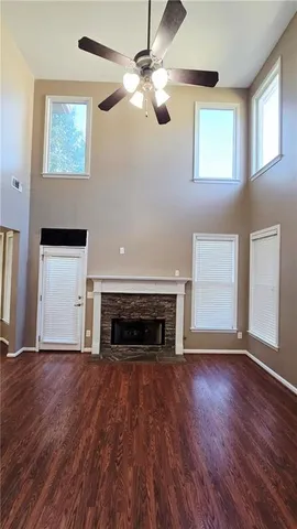 an empty room with wooden floor fireplace and window