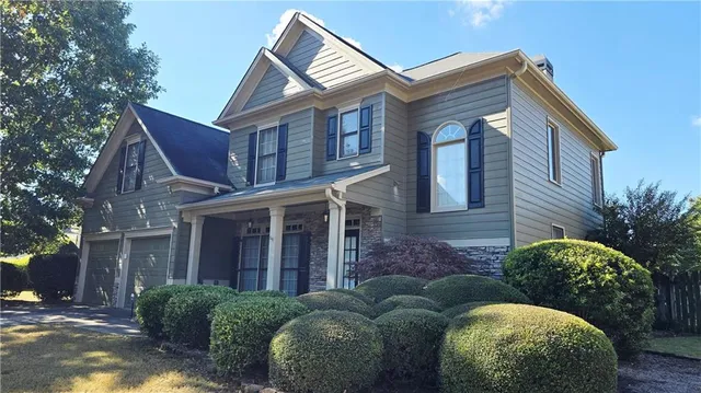 a view of a brick house with a large windows and a yard