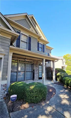 a view of a brick house with a small yard and plants