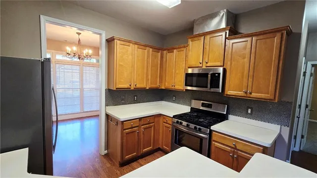a kitchen with stainless steel appliances a stove a microwave and a refrigerator