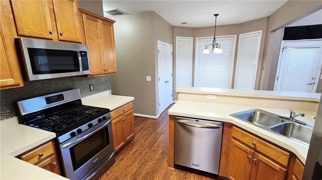 a kitchen with stainless steel appliances granite countertop a stove and a microwave