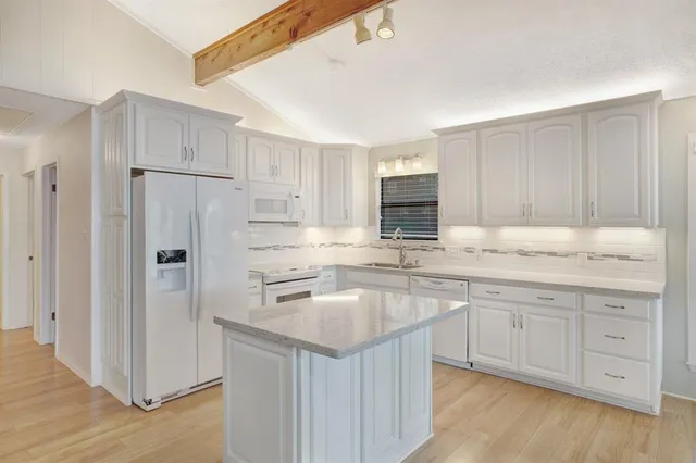 a large kitchen with a sink and cabinets