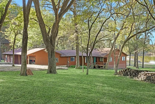 a front view of a house with a garden and trees