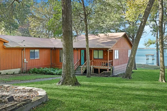 a view of a house with backyard and a tree