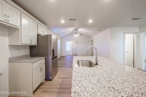 a kitchen with stainless steel appliances granite countertop a refrigerator a stove and a sink