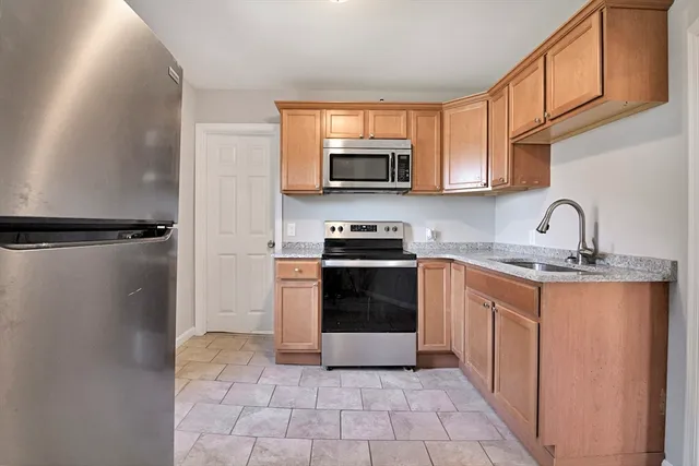 a kitchen with stainless steel appliances granite countertop a refrigerator and a sink