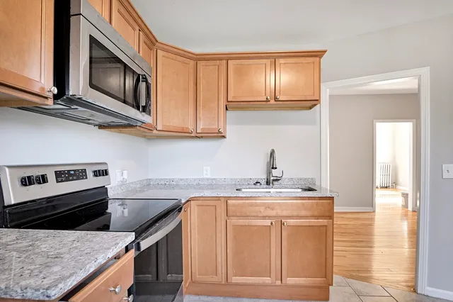a kitchen with stainless steel appliances granite countertop a sink stove and microwave