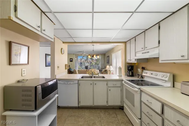 a kitchen with a sink window and cabinets