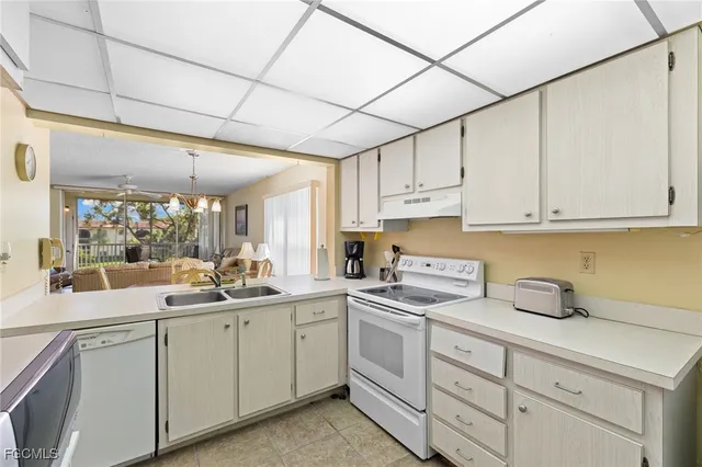 a kitchen with cabinets appliances a sink and a counter top space